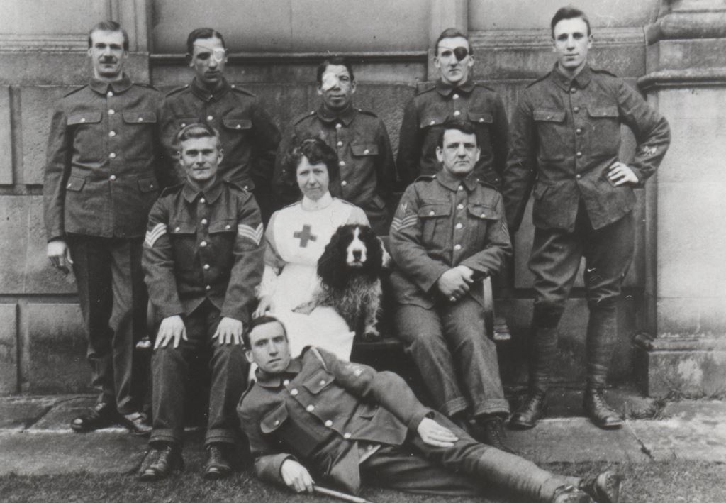 Wounded soldiers, a nurse and a dog outside Attingham Hall, c.1917.